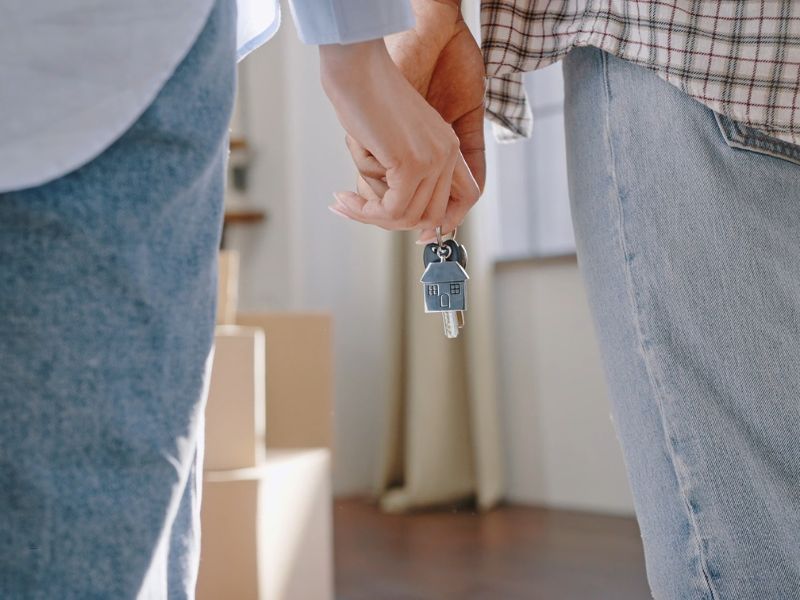 par drži rukama ključ od tek kupljenog stana 