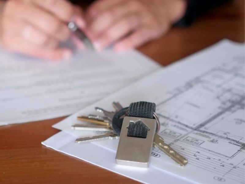 osoba proverava dokumente pri kupovini stana na kojima su ključevi od stana