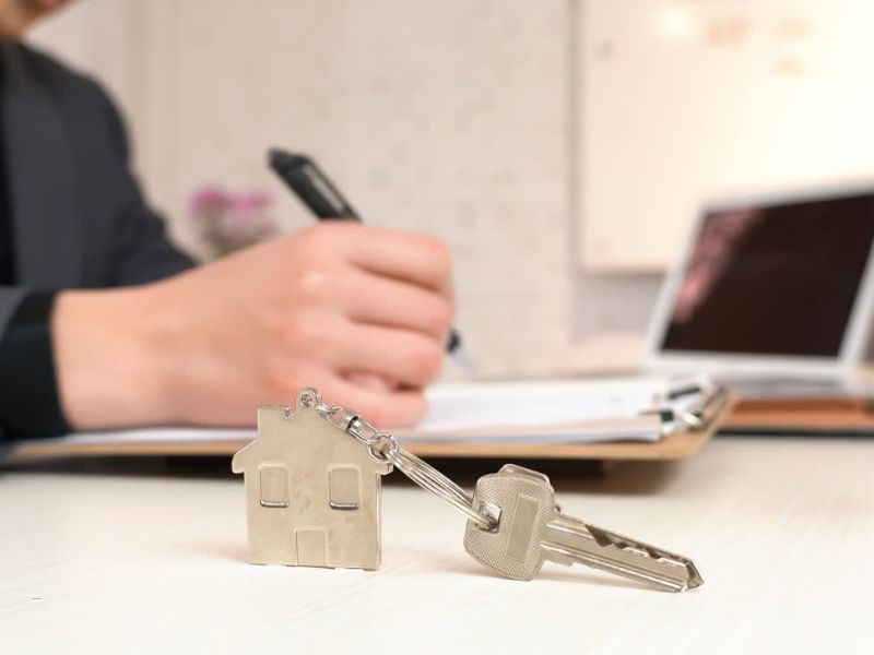 osoba proverava unjiženost stana, zapisuje nešto na dokumente, pored nje ključ od stana